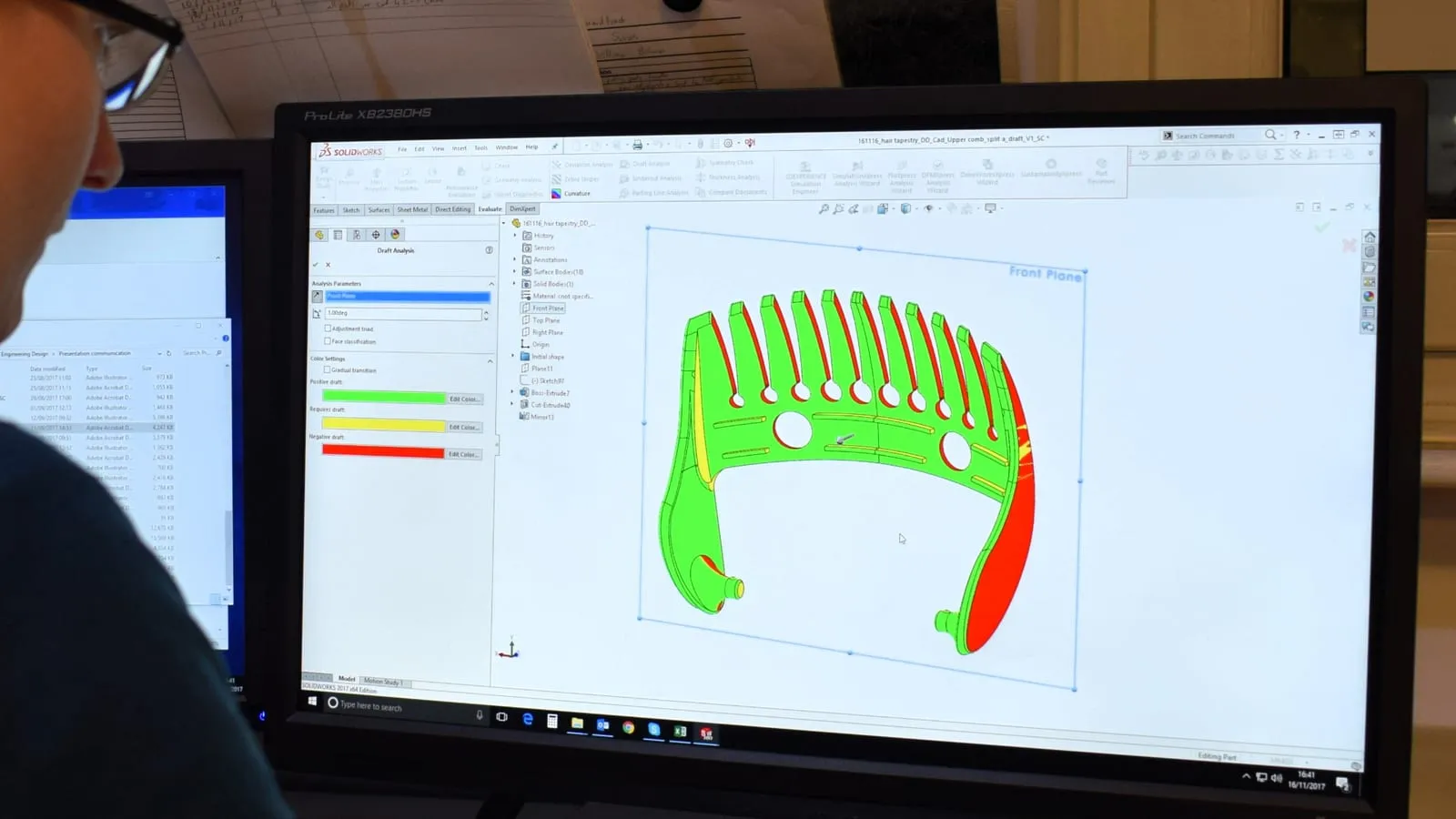 A SolidWorks draft analysis on screen with the parameter set to 1 degree, shading the moulded part green where draft passes, yellow where it needs draft and red for negative draft.