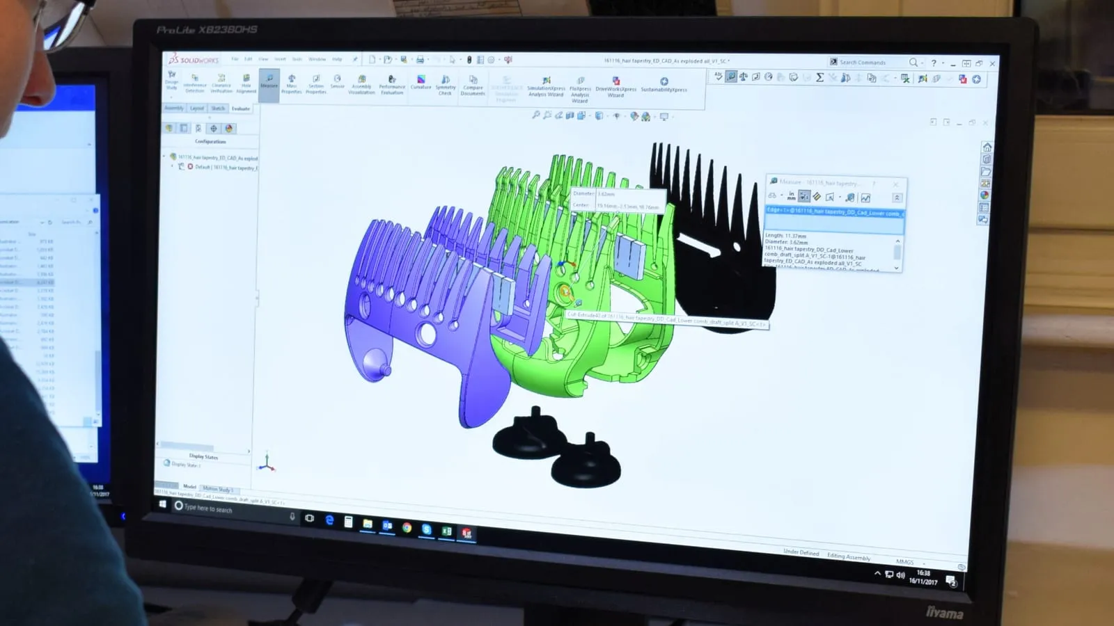 A SolidWorks exploded assembly on a monitor, its components coloured green, purple and black and separated in space, with the measure tool reporting a 3.62mm diameter.