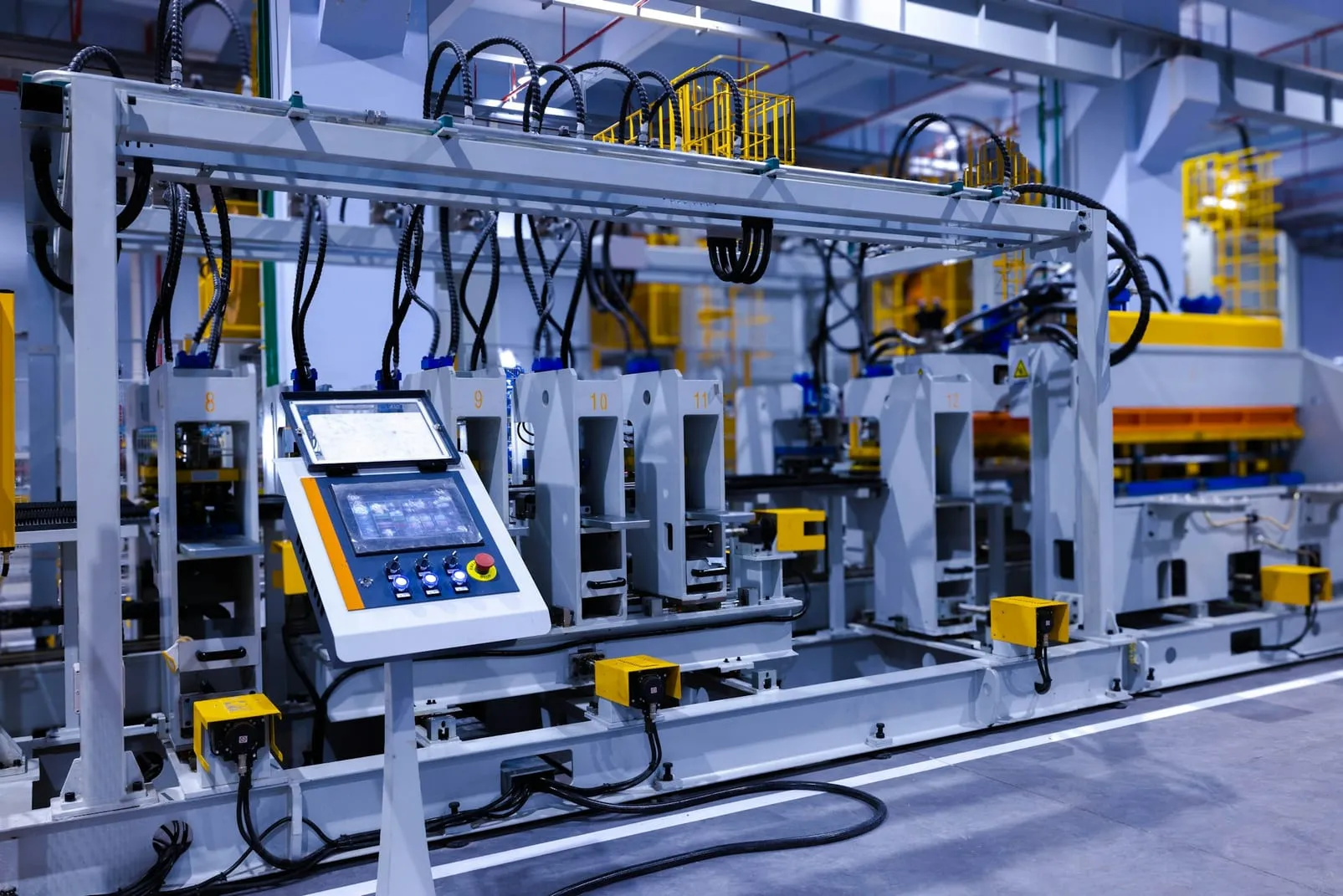 An automated factory production line with numbered press stations and an operator control panel