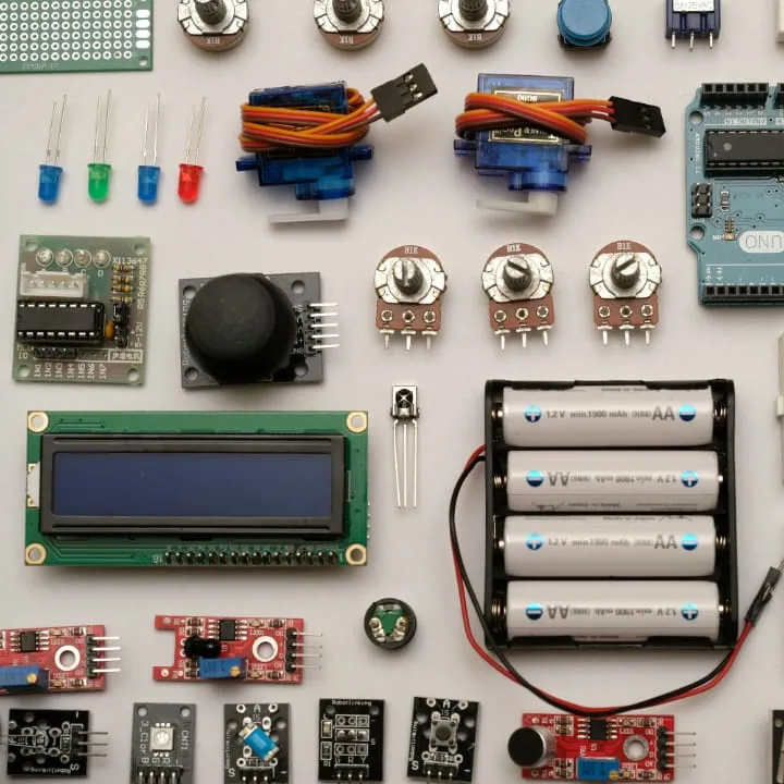 A flat lay of off-the-shelf prototyping electronics, cropped square: servos, coloured LEDs, potentiometers, an LCD module, a battery holder and assorted sensor boards.
