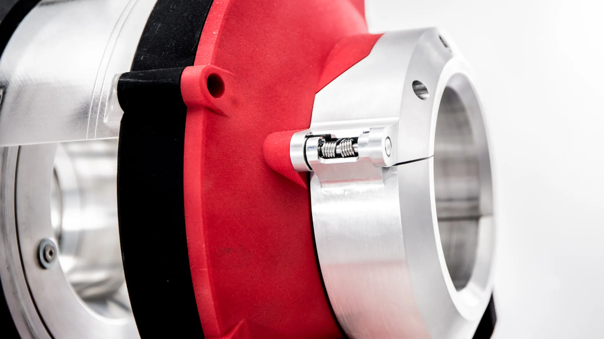 A close up of the cutting head, showing the sprung mechanism that drives the blade carriage radially inward against the red body and the machined aluminium ring.