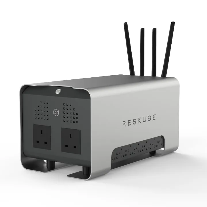 The Reskube, a brushed aluminium box on low feet with four aerials on top, two UK mains sockets and a vented panel on its black end face, and the Reskube name on the side.