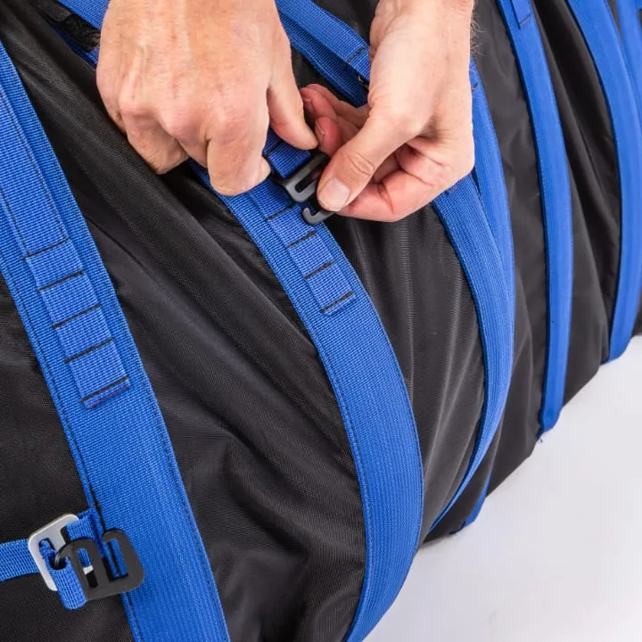 Close-up of two hands adjusting a blue webbing strap and buckle on a black recycled-fabric board bag.